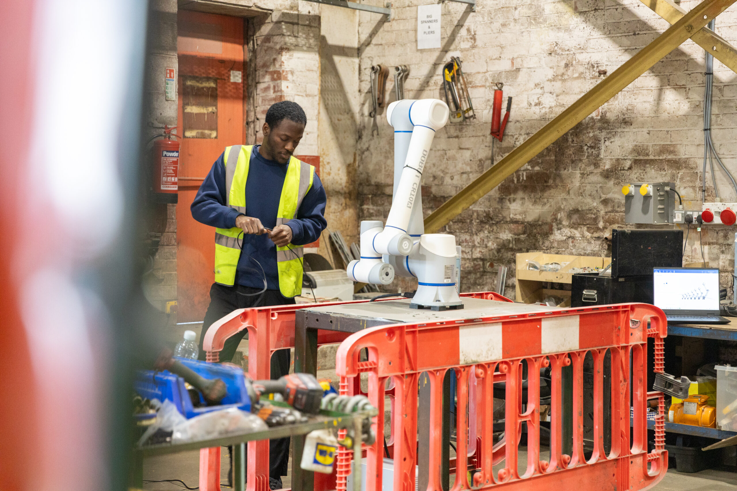 Heyside Group team member uses robot arm as part of production process
