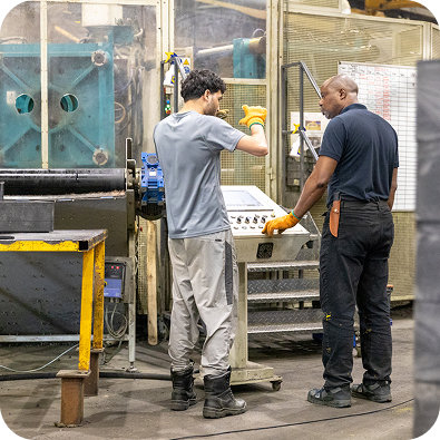 Operatives using injection moulding machinery at Heyside Group